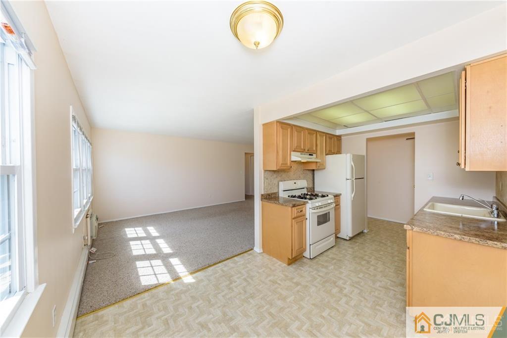 48 Stonehurst Boulevard, Unit E Freehold, NJ 07728 - Photo 8 of 15 a kitchen with a stove a sink and a refrigerator