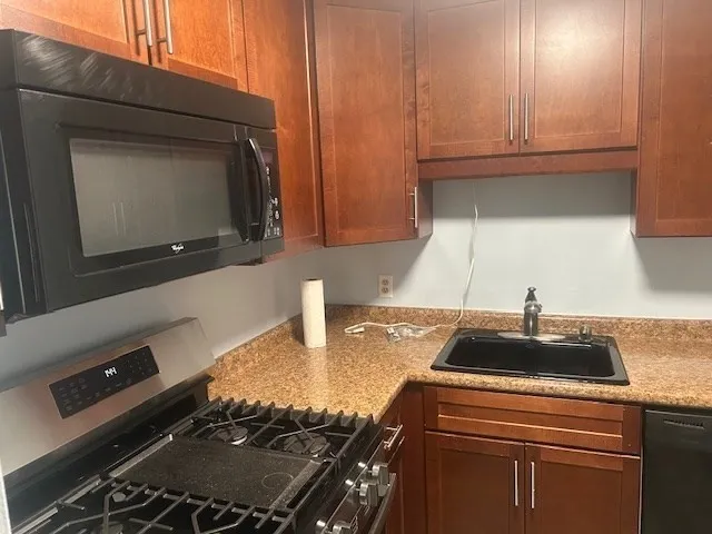a kitchen with granite countertop a sink and a stove