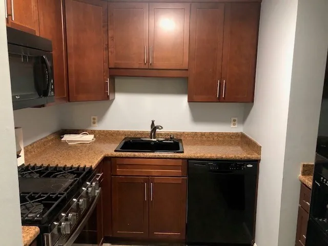 a kitchen with granite countertop a stove and a refrigerator