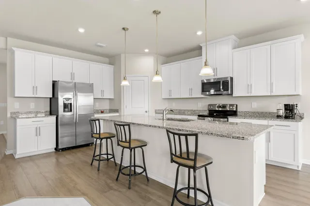a kitchen with kitchen island granite countertop a center island a sink cabinets and stainless steel appliances
