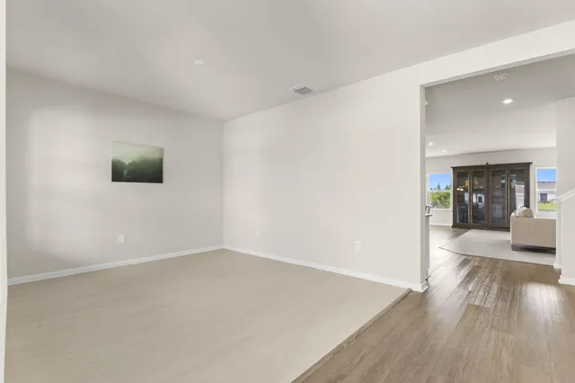 a view of a living room hardwood floor and a kitchen