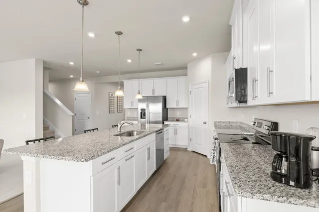 a kitchen with stainless steel appliances kitchen island granite countertop a sink stove and cabinets