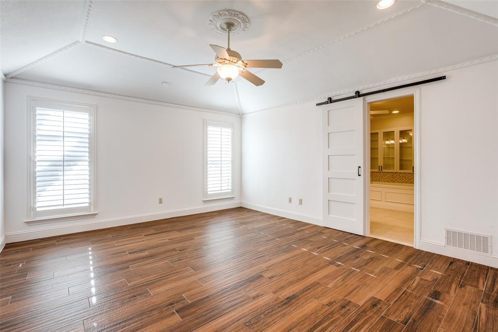 3202 Ridge Oak Drive Garland, TX 75044 - Photo 19 of 25 an empty room with wooden floor chandelier fan and windows