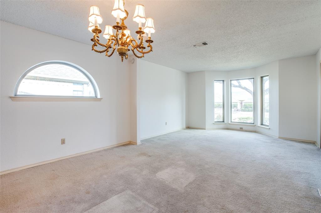 3202 Ridge Oak Drive Garland, TX 75044 - Photo 6 of 25 an empty room with a chandelier fan and a windows