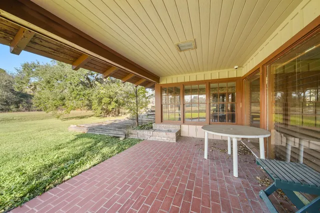 a view of a house with a big yard and large trees