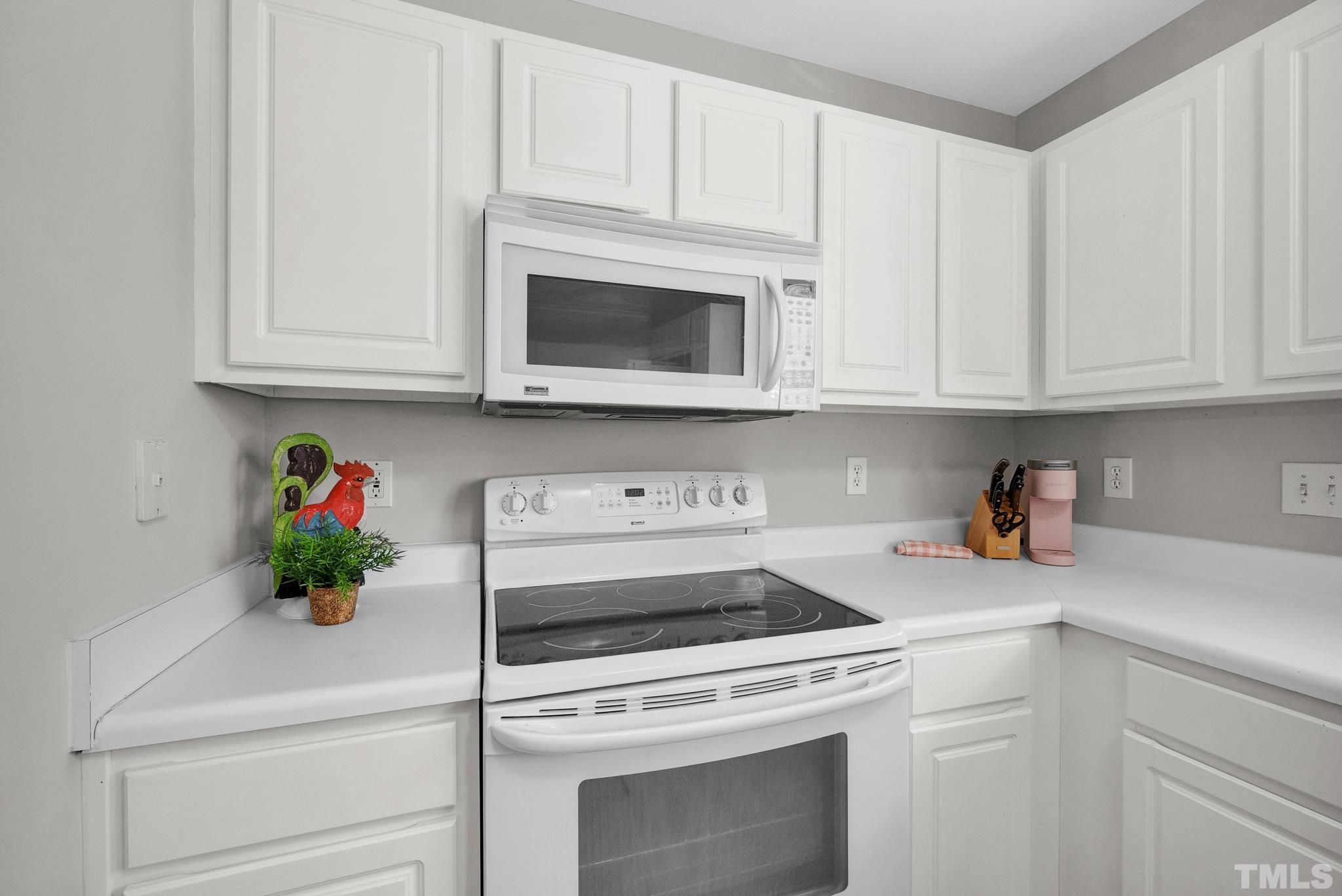 9553 Hanging Rock Road Raleigh, NC 27613 - Photo 11 of 36 a kitchen with white cabinets and white appliances