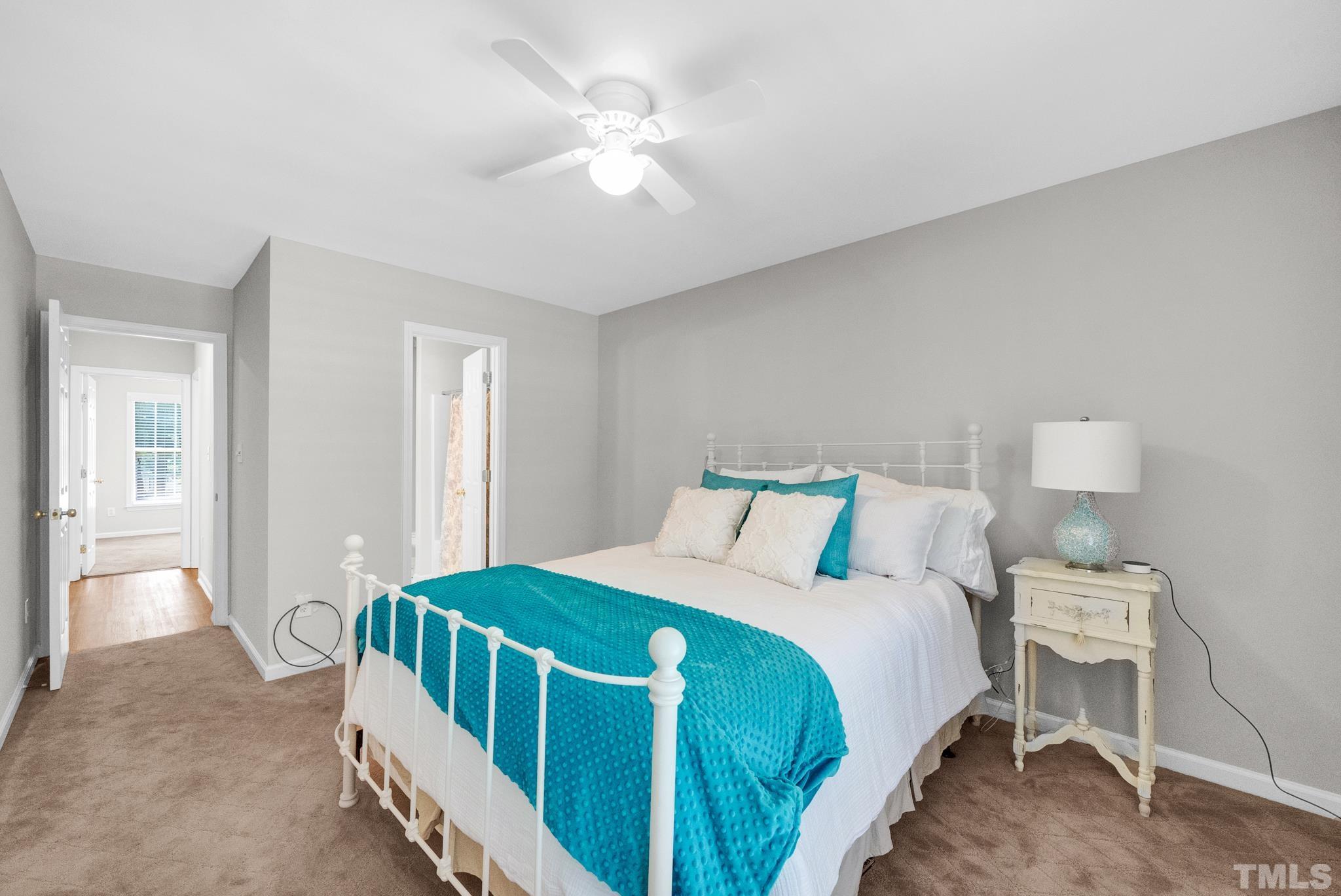 9553 Hanging Rock Road Raleigh, NC 27613 - Photo 14 of 36 a bedroom with a bed and a chandelier