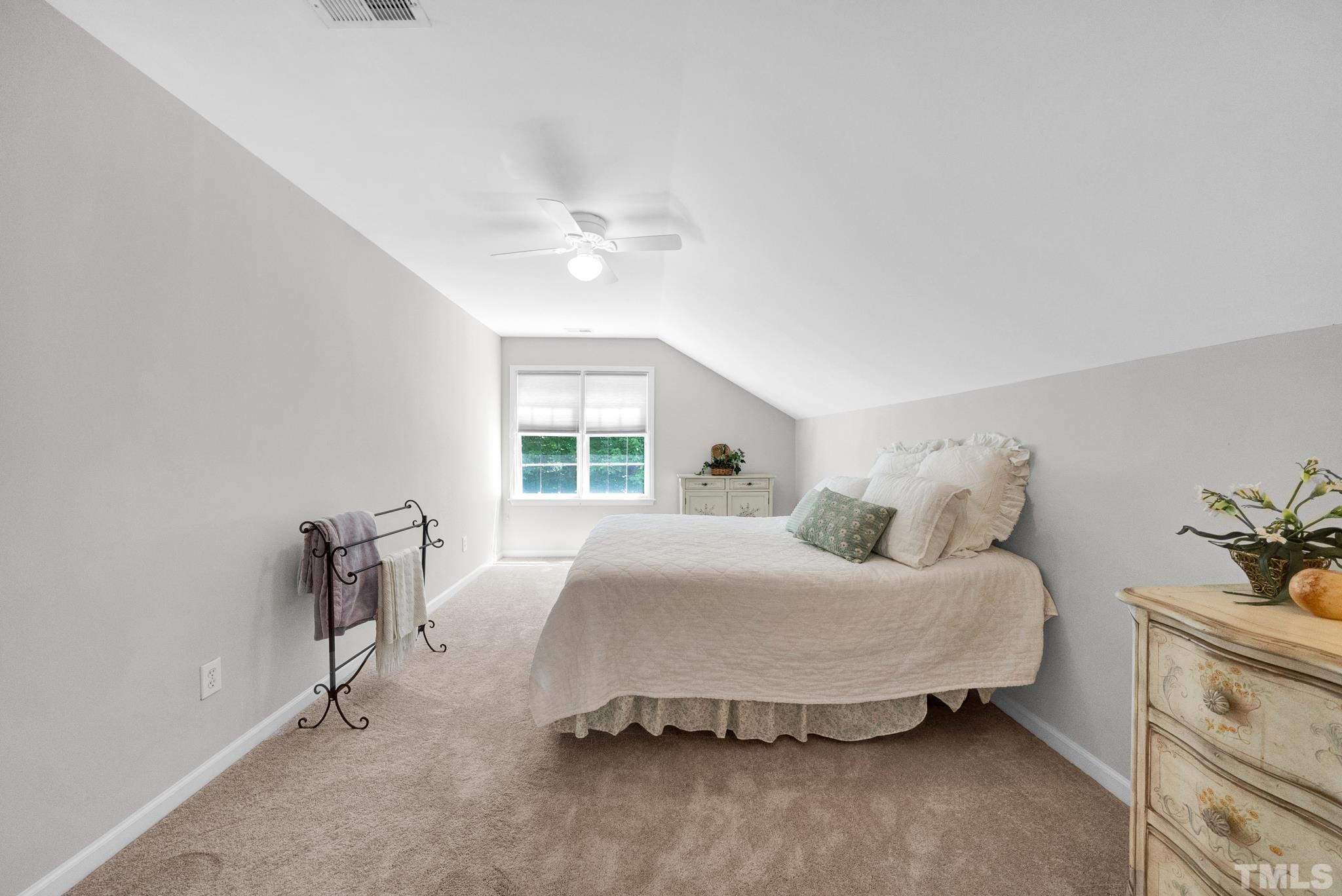 9553 Hanging Rock Road Raleigh, NC 27613 - Photo 24 of 36 a bedroom with a bed and a table with lamp