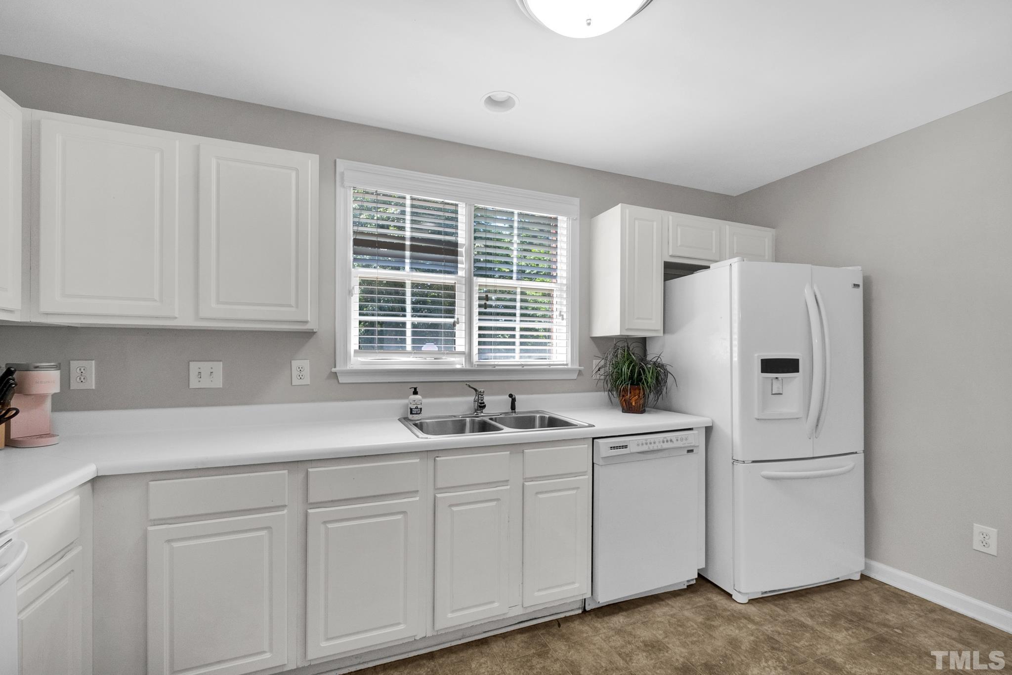 9553 Hanging Rock Road Raleigh, NC 27613 - Photo 3 of 36 a kitchen with white cabinets and white appliances