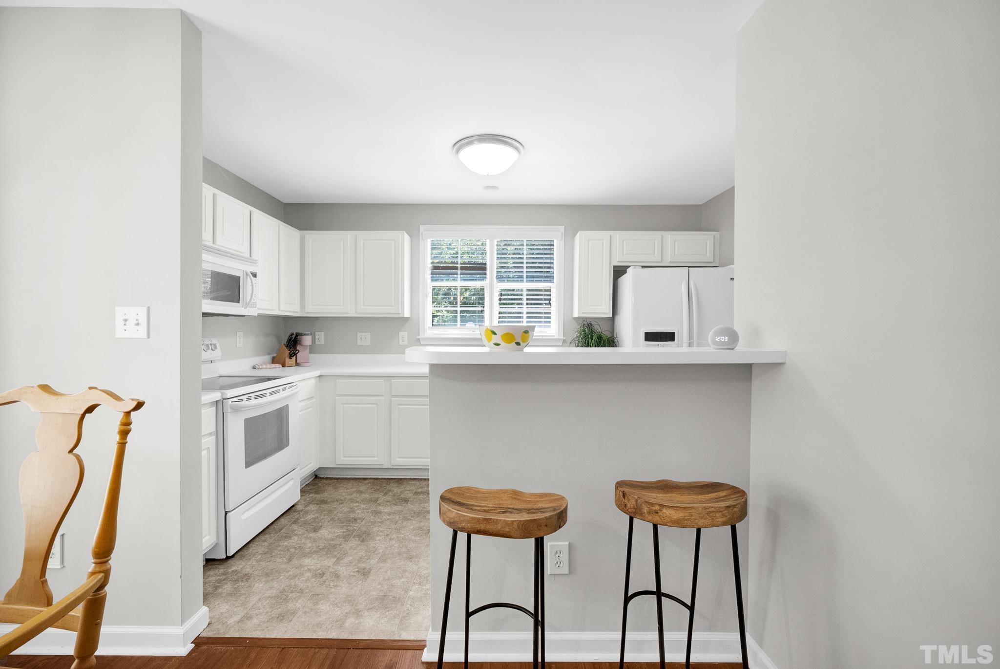 9553 Hanging Rock Road Raleigh, NC 27613 - Photo 8 of 36 a kitchen with stainless steel appliances a table and chairs in it