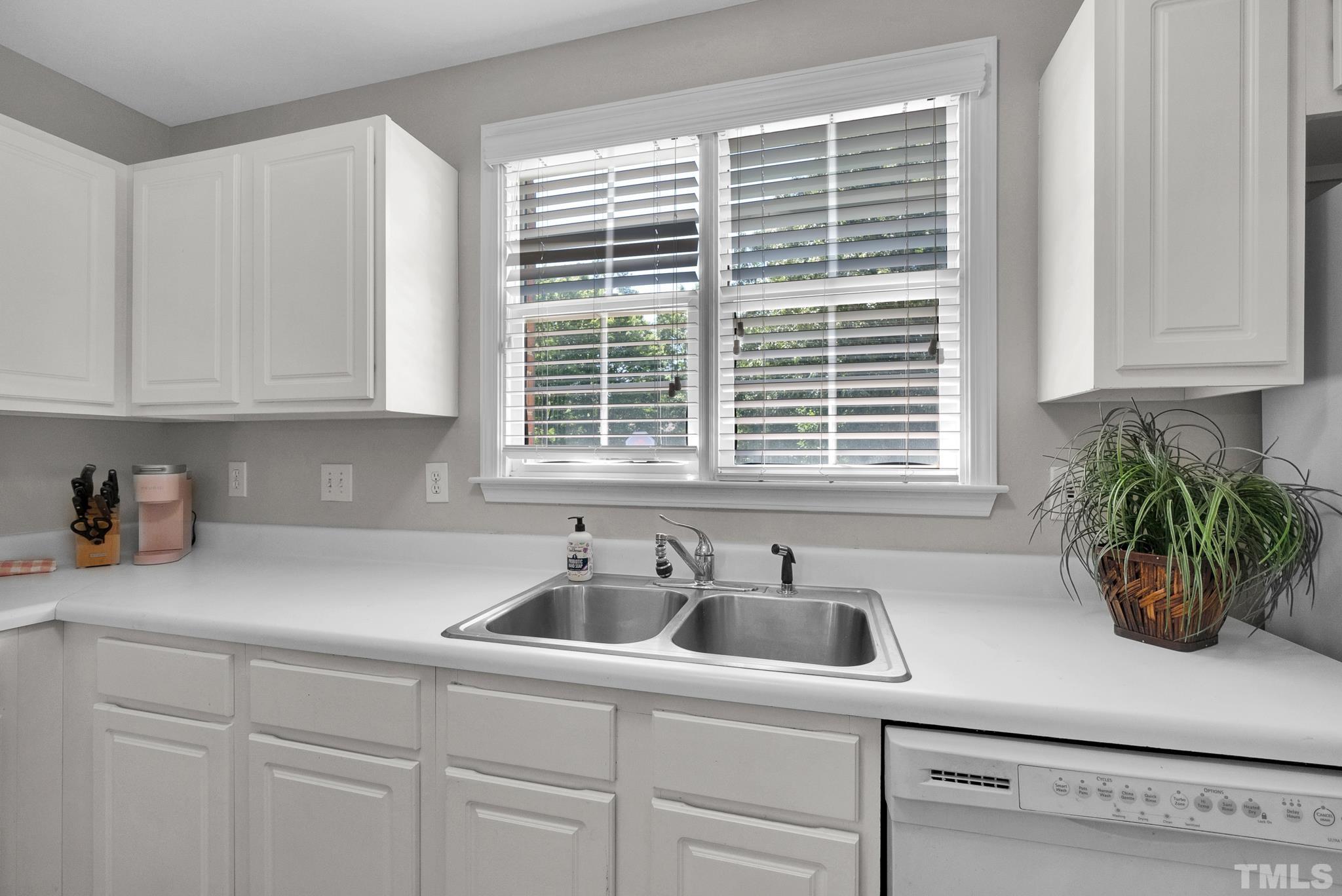 9553 Hanging Rock Road Raleigh, NC 27613 - Photo 10 of 36 a kitchen with stainless steel appliances a sink a window and cabinets