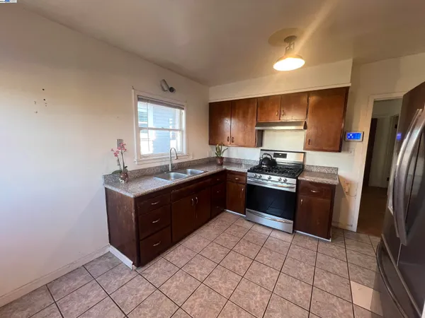 a kitchen with granite countertop a refrigerator and a sink