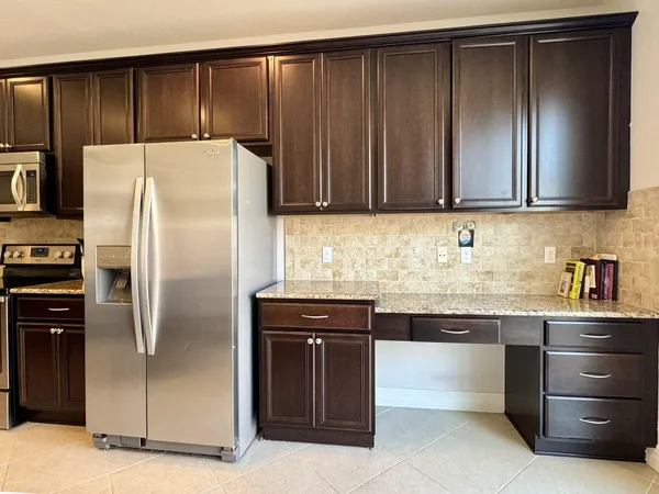 a kitchen with a refrigerator sink and cabinets