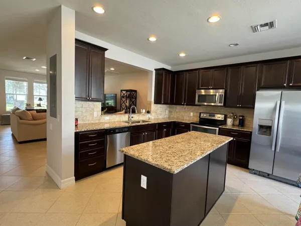 a kitchen with a refrigerator a sink a stove a microwave and cabinets