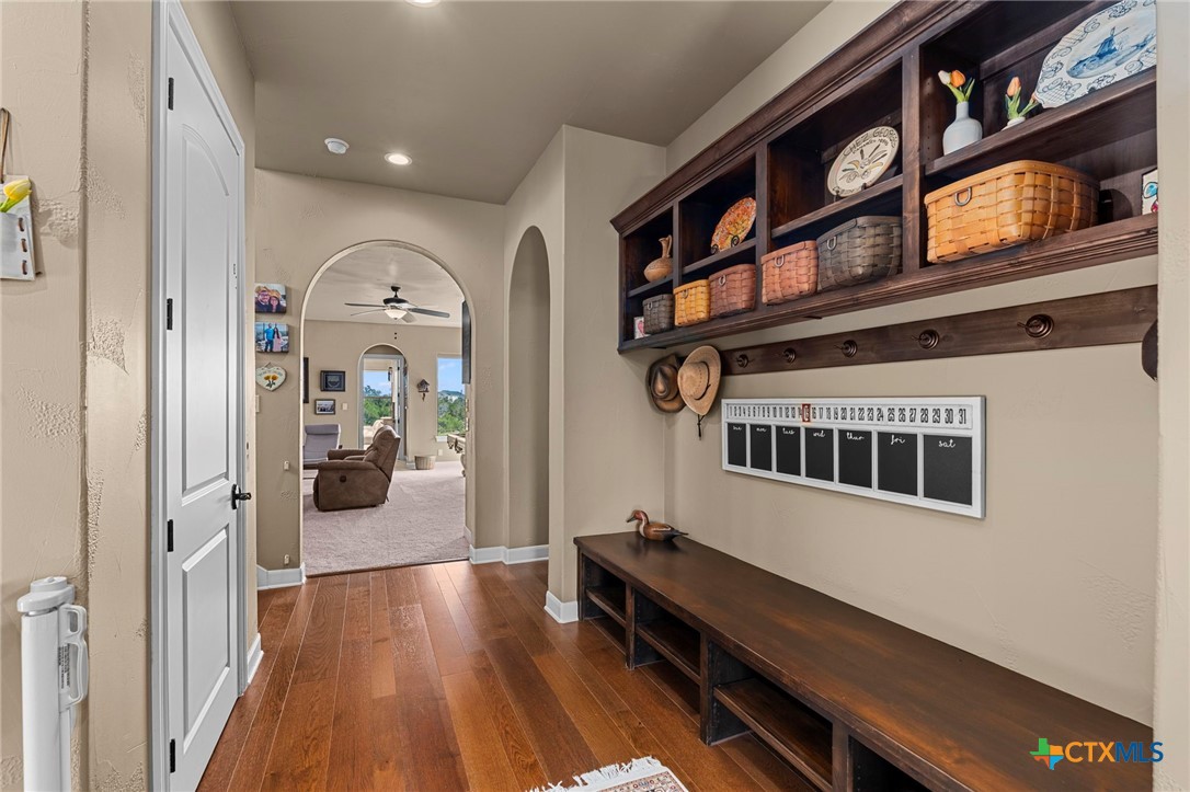 1039 Bluewater Place Spring Branch, TX 78070 - Photo 8 of 48 a hallway with wooden floor a book shelf and living room
