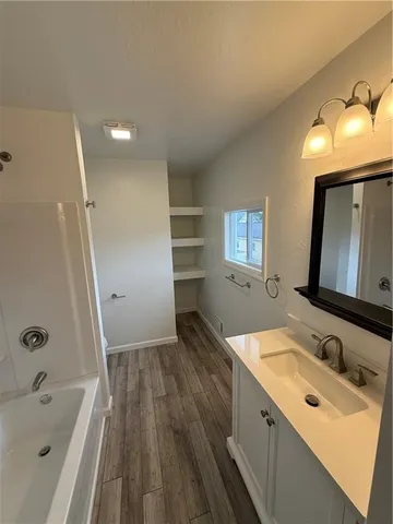 a bathroom with a tub sink and mirror