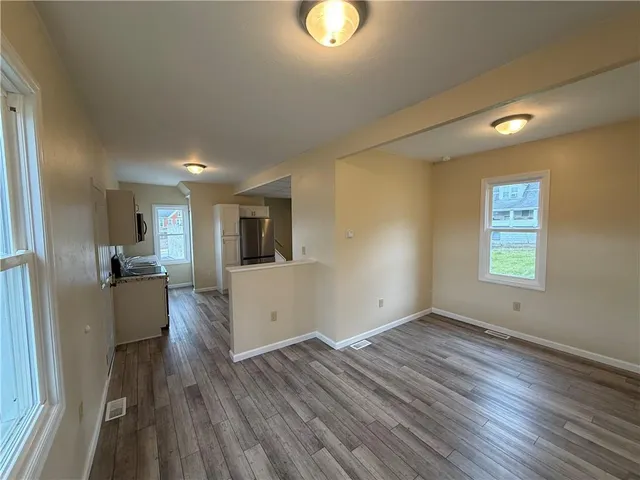 a view of a kitchen with wooden floor and a window