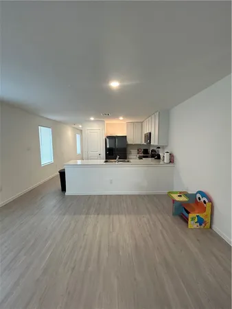 a view of a kitchen with furniture and wooden floor