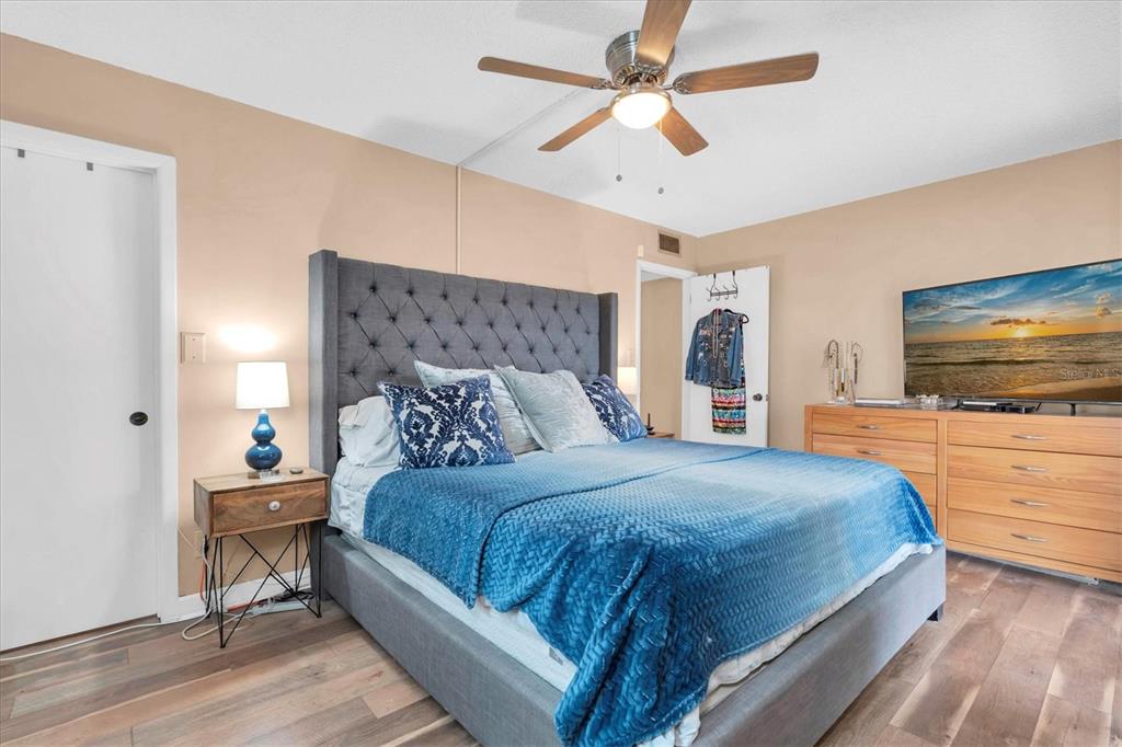 8800 Blind Pass Road, Unit 10 St. Pete Beach, FL 33706 - Photo 12 of 24 a bedroom with a bed and a flat screen tv