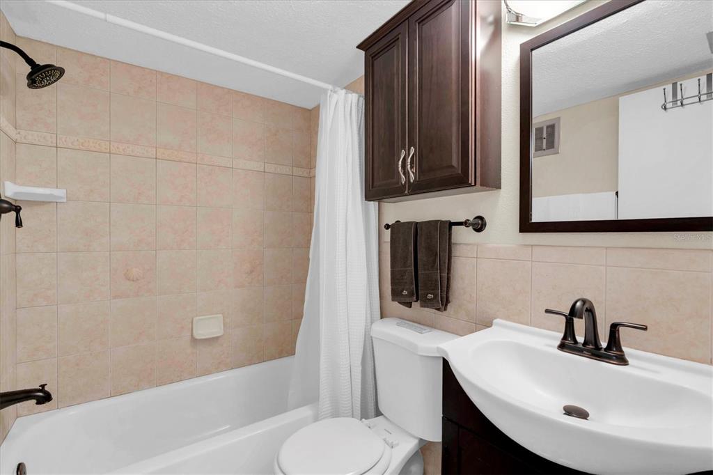 8800 Blind Pass Road, Unit 10 St. Pete Beach, FL 33706 - Photo 16 of 24 a bathroom with a sink toilet and shower