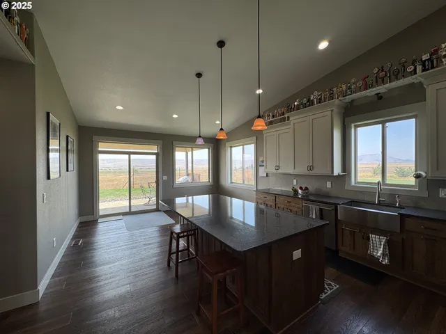 a kitchen with granite countertop a sink appliances and wooden floor