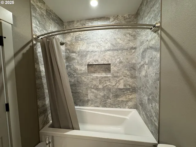 a bathroom with a shower and a bath tub