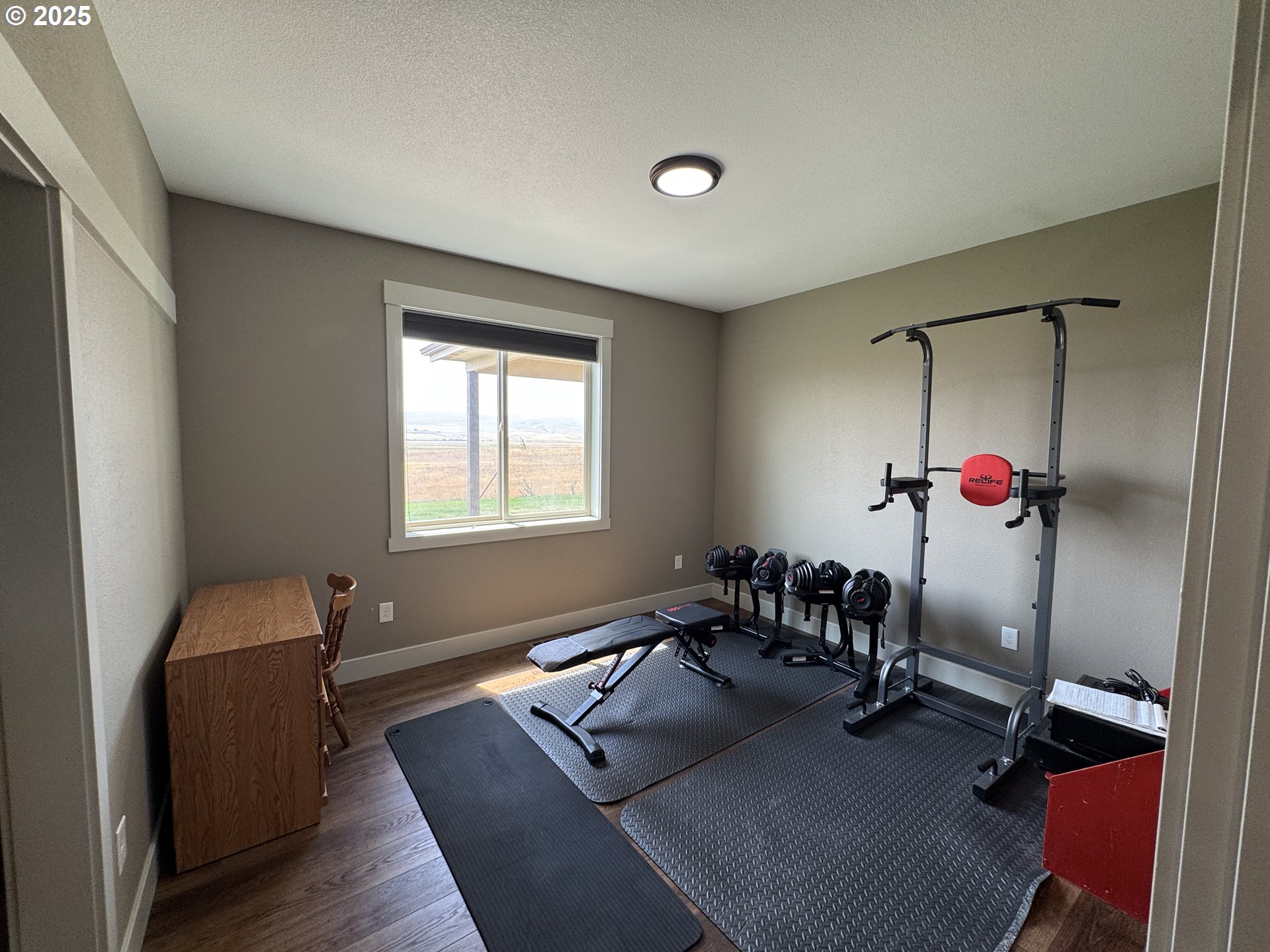 1818 Centerville Highway Centerville, WA 98613 - Photo 22 of 42 a room with gym equipment and wooden floor