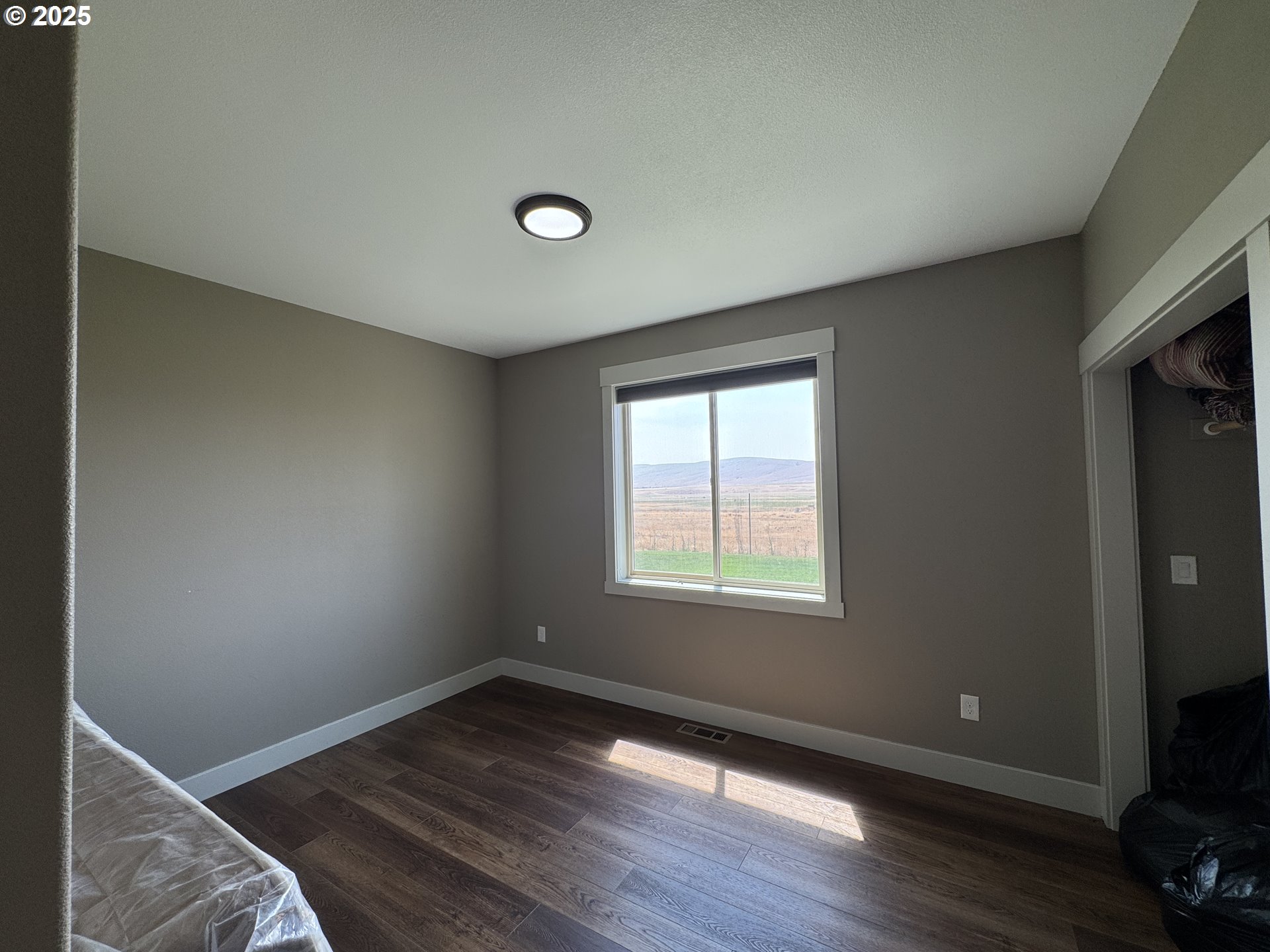 1818 Centerville Highway Centerville, WA 98613 - Photo 23 of 42 an empty room with wooden floor and windows