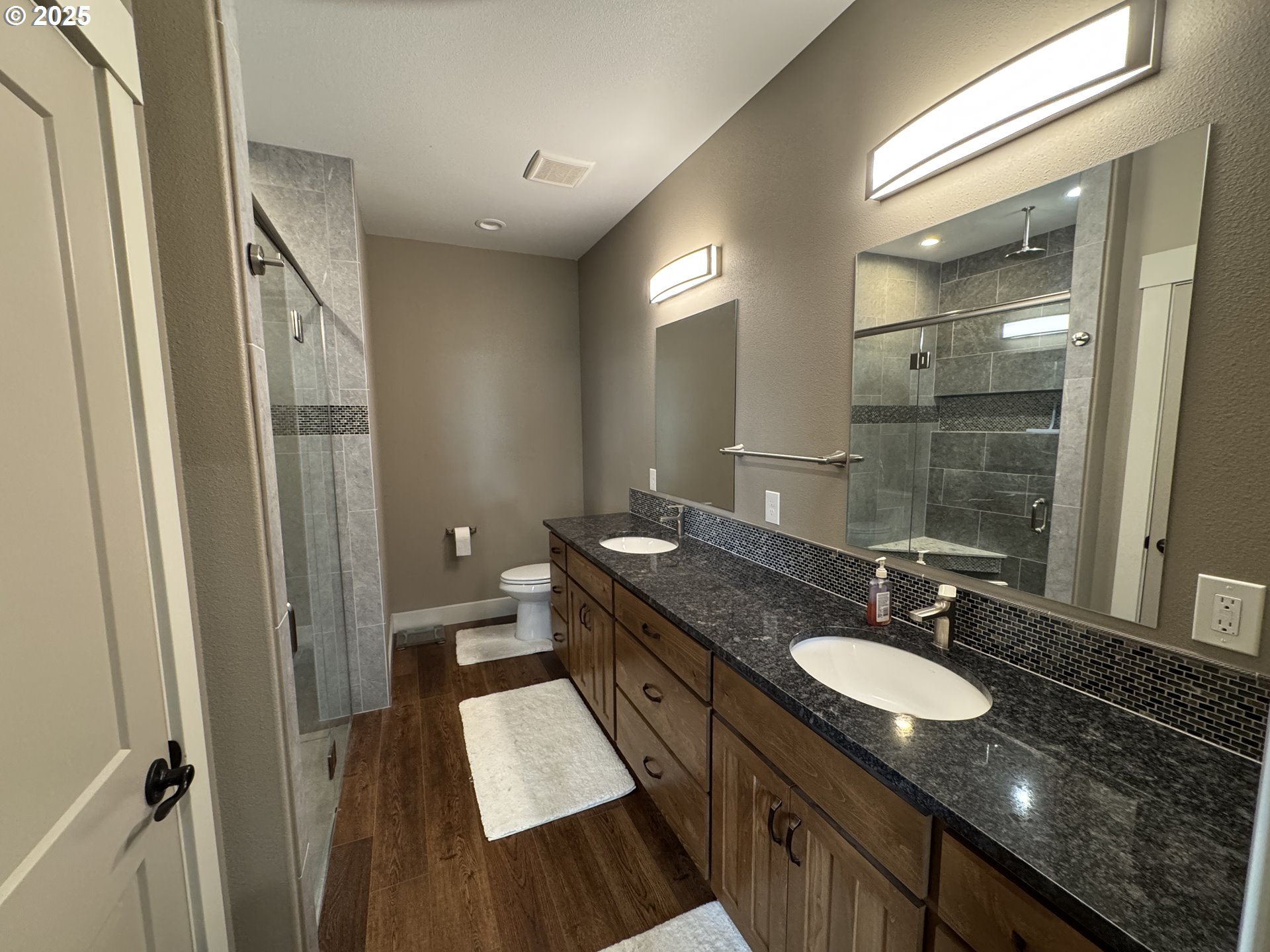 1818 Centerville Highway Centerville, WA 98613 - Photo 27 of 42 a bathroom with a granite countertop sink a mirror a vanity and a shower
