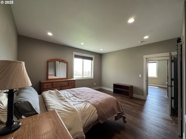 a bedroom with a bed and a large window