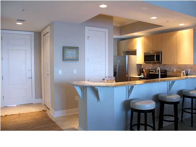 211 Durango Road, Unit 416 Destin, FL 32541 - Photo 10 of 34 a kitchen with stainless steel appliances kitchen island granite countertop a sink and a refrigerator
