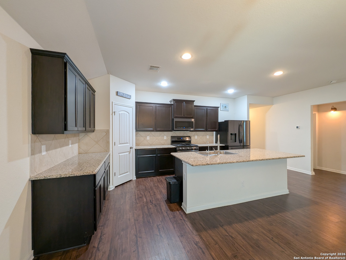 2494 McCrae New Braunfels, TX 78130 - Photo 5 of 22 a kitchen with stainless steel appliances a stove top oven a sink dishwasher and a refrigerator with wooden floor