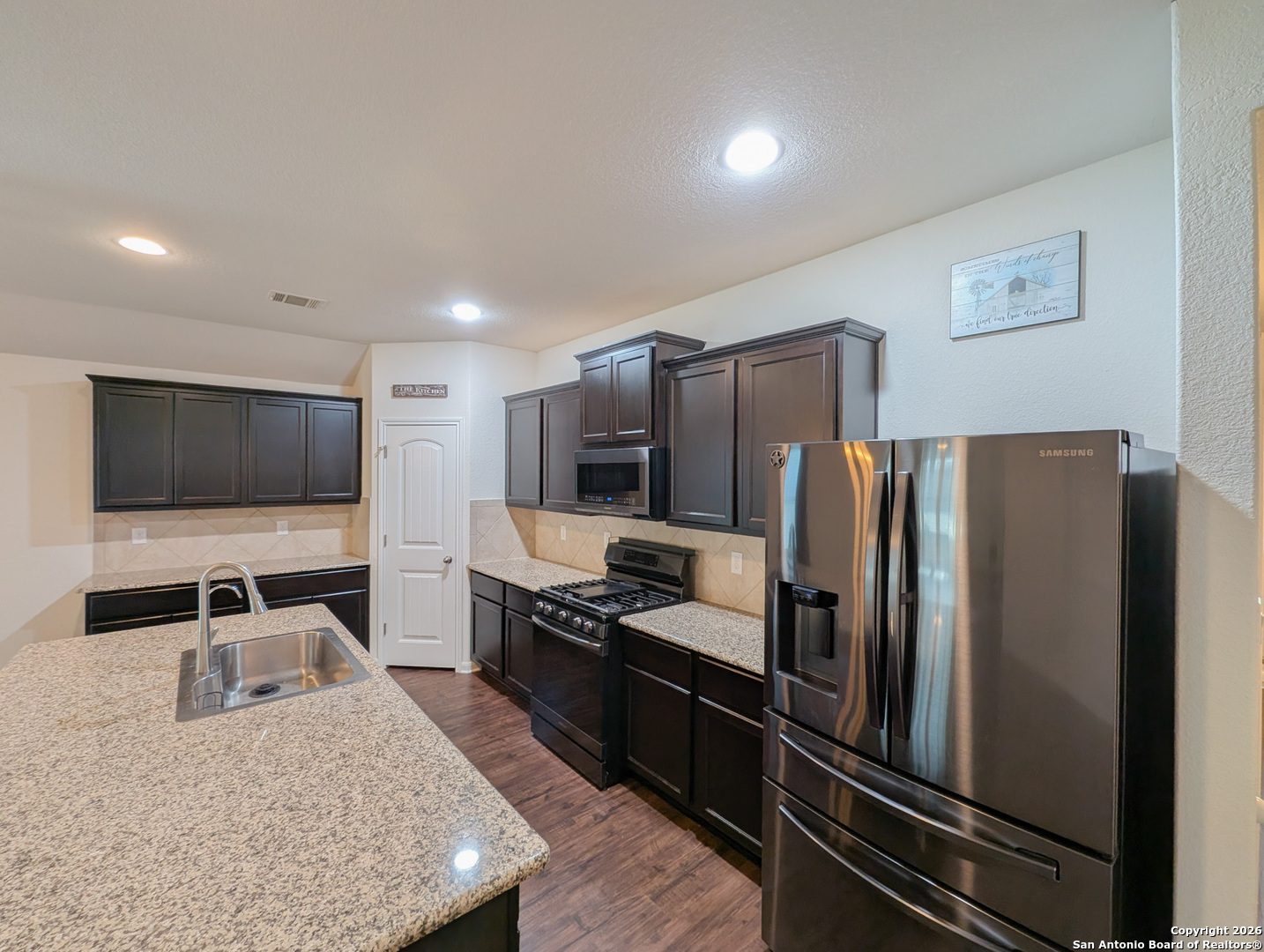 2494 McCrae New Braunfels, TX 78130 - Photo 6 of 22 a kitchen with stainless steel appliances granite countertop a refrigerator and a sink