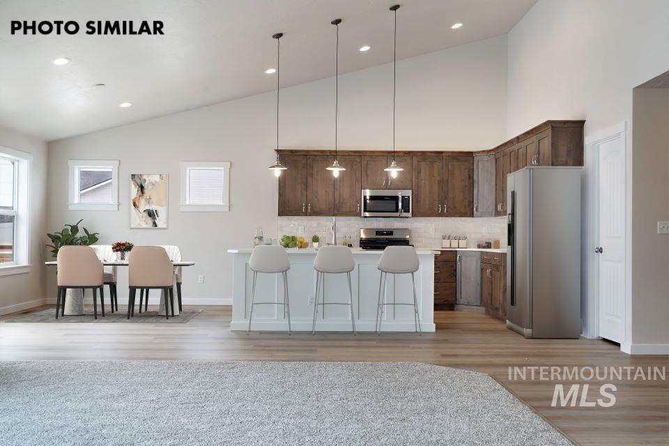 1645 Haystack Emmett, ID 83617 - Photo 7 of 33 Open-concept kitchen and dining area featuring wood-finish flooring, vaulted ceilings, and recessed lighting