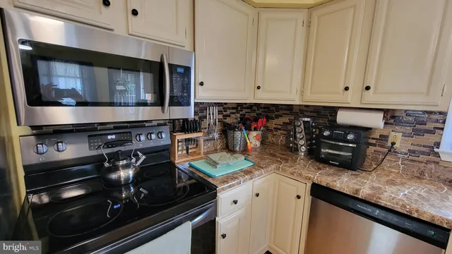 a kitchen with appliances a sink and cabinets
