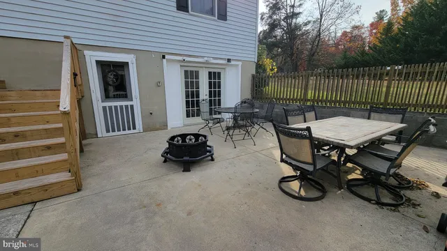 a view of a patio with dining table and chairs with wooden fence