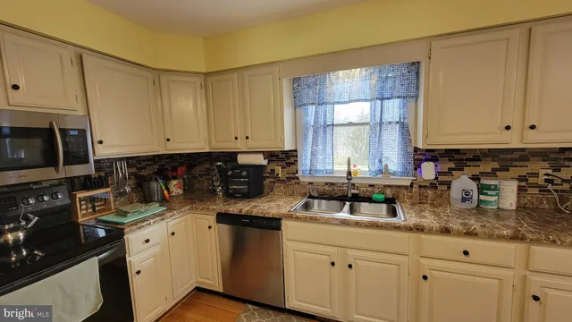 a kitchen with granite countertop white cabinets and white appliances