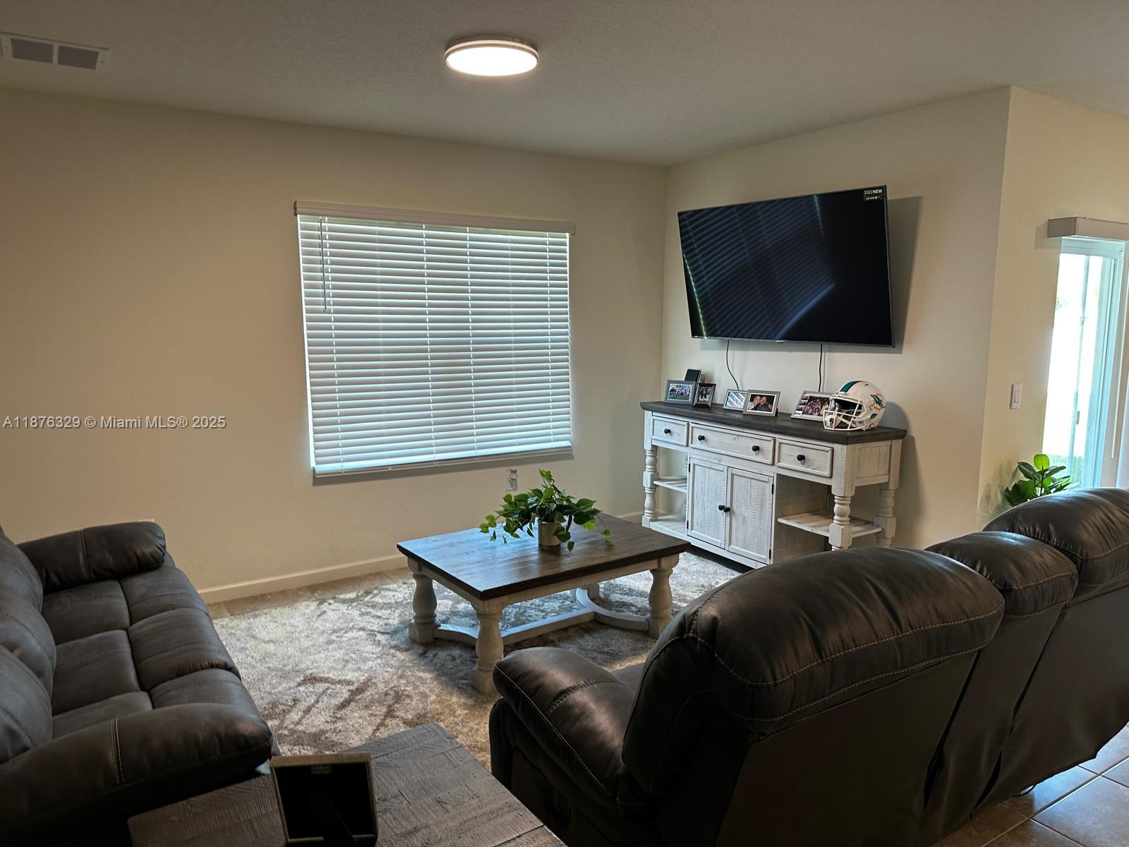 2098 Southwest Altman Avenue Port St. Lucie, FL 34953 - Photo 12 of 27 a living room with furniture and a flat screen tv