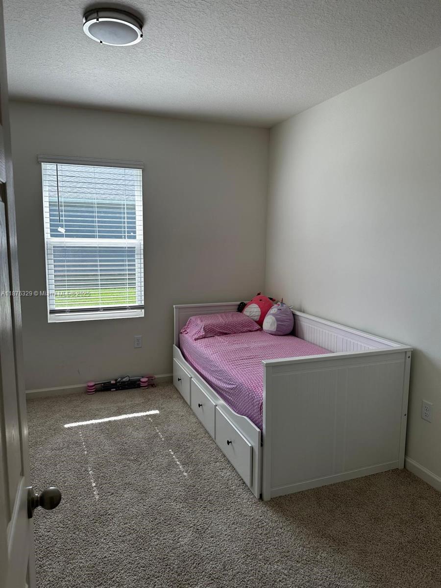 2098 Southwest Altman Avenue Port St. Lucie, FL 34953 - Photo 15 of 27 a spacious bedroom with a bed and a window
