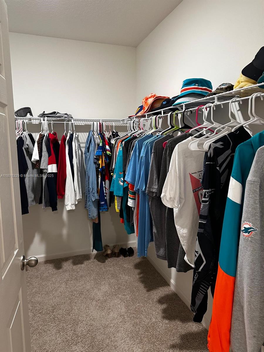 2098 Southwest Altman Avenue Port St. Lucie, FL 34953 - Photo 17 of 27 a view of walk in closet with clothes and shoes