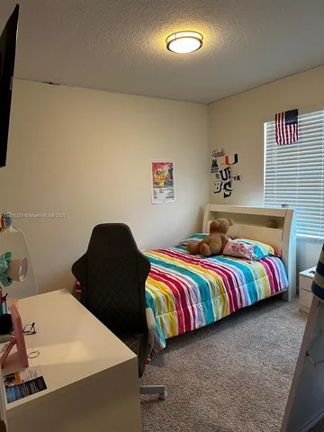 a bedroom with a bed and painting on the wall