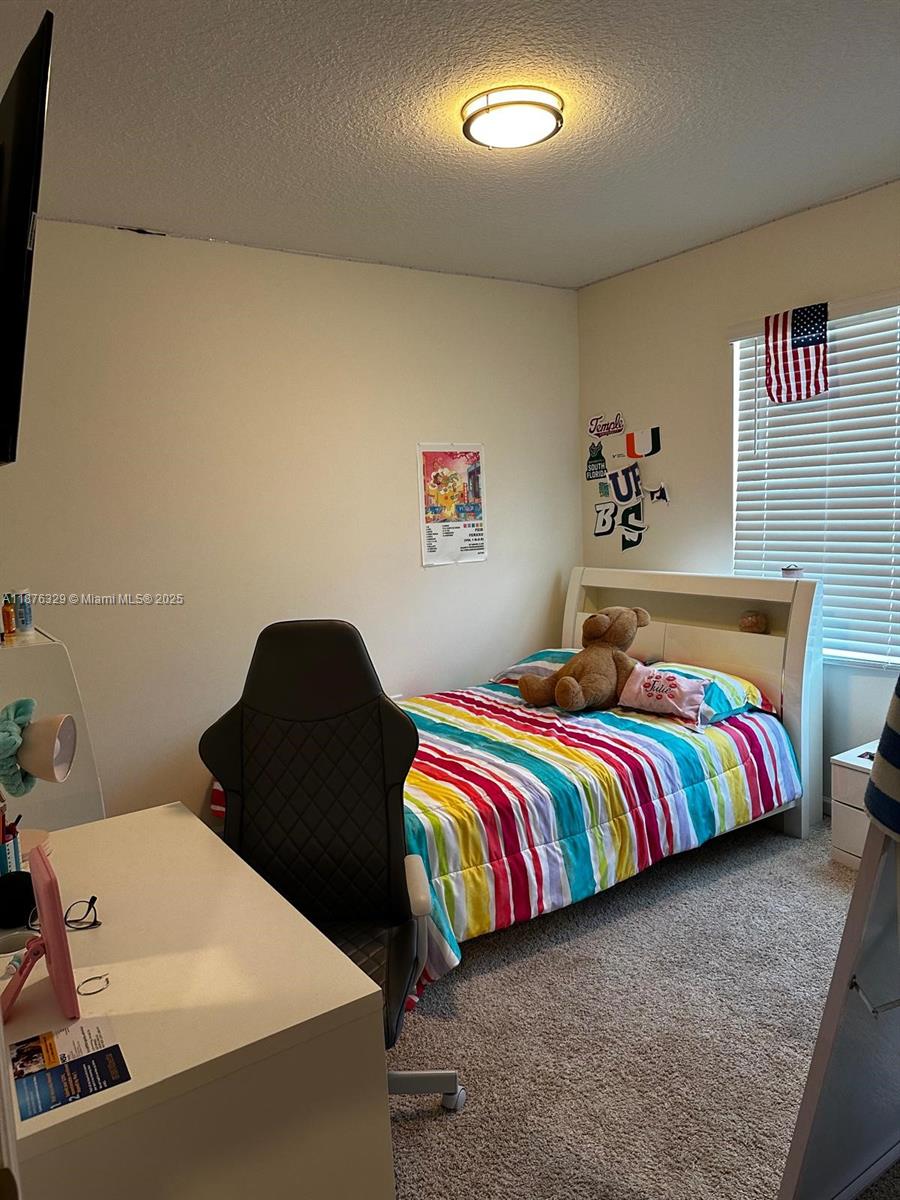 2098 Southwest Altman Avenue Port St. Lucie, FL 34953 - Photo 21 of 27 a bedroom with a bed and painting on the wall