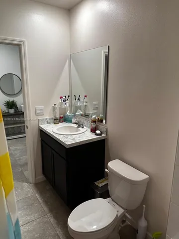 a bathroom with a sink vanity mirror and toilet