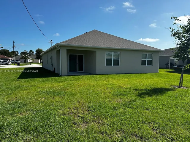 a view of a house next to a yard with a fountain