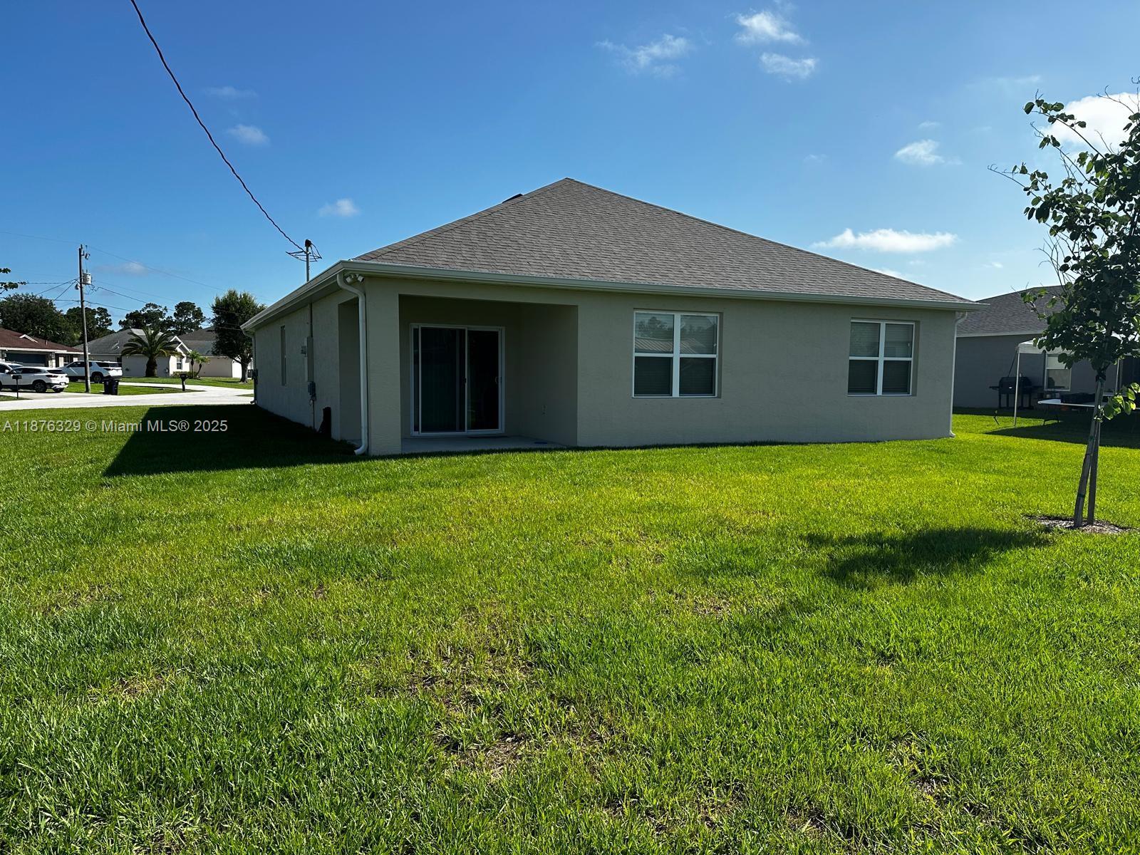 2098 Southwest Altman Avenue Port St. Lucie, FL 34953 - Photo 3 of 27 a view of a house next to a yard with a fountain