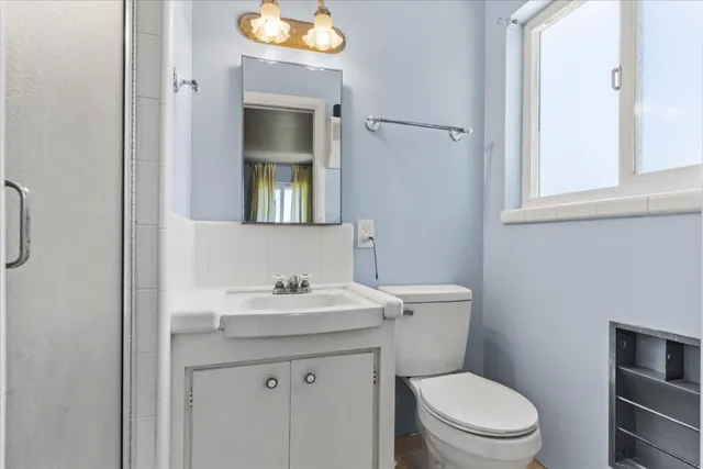 a bathroom with a toilet sink and mirror