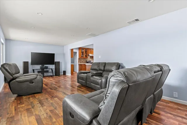 a living room with furniture and a wooden floor