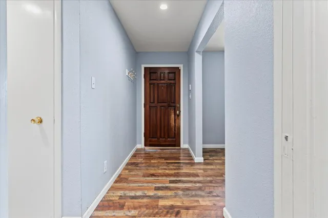a view of a hallway with wooden floor