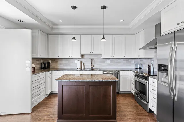 a kitchen with stainless steel appliances granite countertop a stove a sink dishwasher and a refrigerator