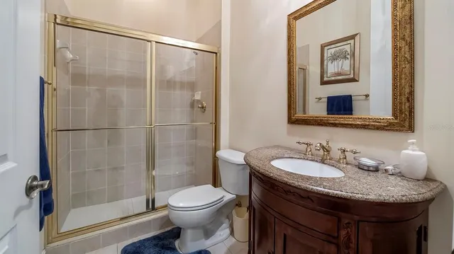 a bathroom with a granite countertop sink a toilet and shower